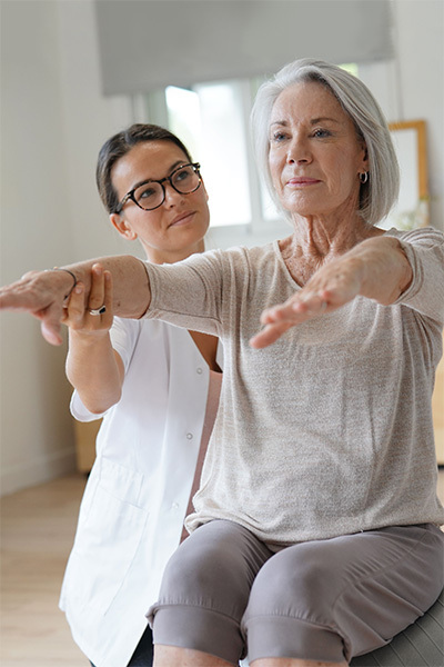 Woman helping senior woman lift her arms