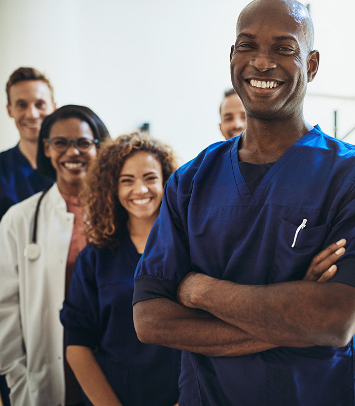 Staff in blue scrubs smiling